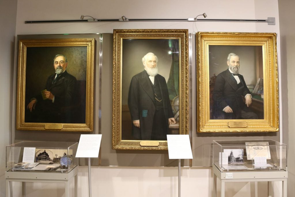 Portraits of founders Henry Wells (1805-1878) and William G. Fargo (1818-1881) aside later owner Isaias W. Hellman (1842-1920).