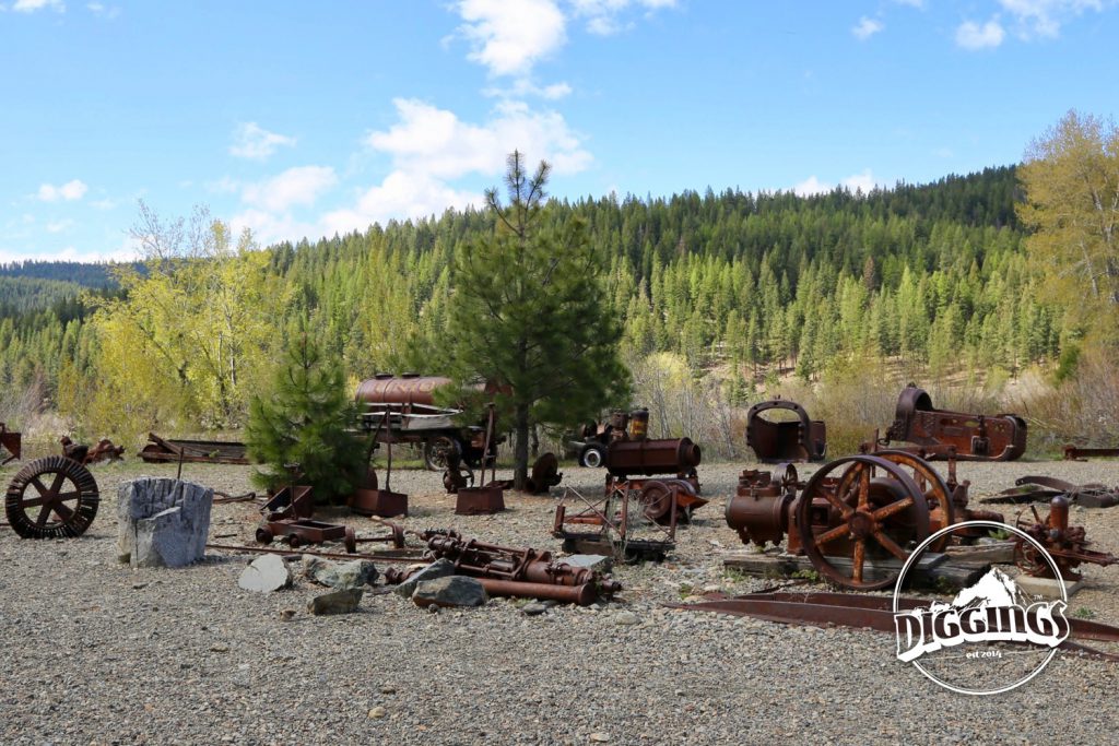 On the far side of the dredge is a yard full of rusting mining equipment at the Sumpter Valley Dredge State Heritage Area
