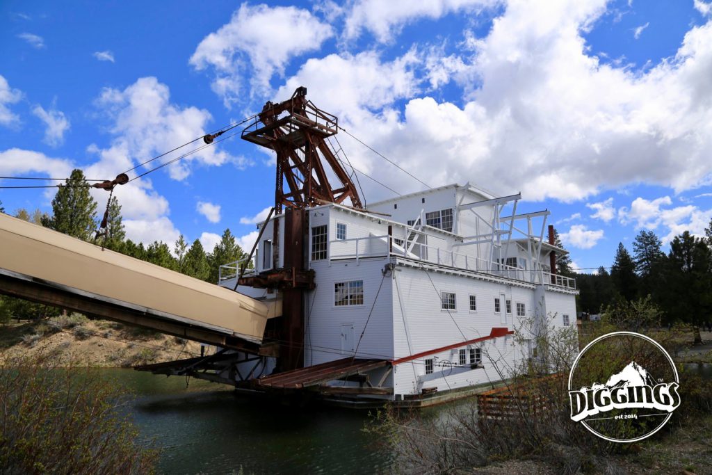 A rear view of the dredge with the covered "stacker" hovering over the dredges last tailings at the Sumpter Valley Dredge State Heritage Area